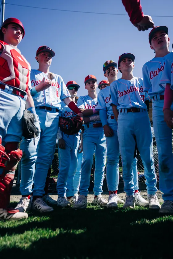 Abbotsford Cardinals players gather together on the field before a game.